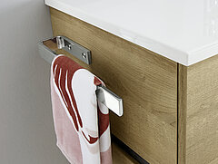 Bad Rimini: Detail Handtuchhalter ZHH4320 zur Korpusmontage an Waschtisch-Unterschrank W01013M9904 mit 2 Auszügen inkl. Kosmetik-Einsatz, Mineralmarmor-Waschtisch Weiß BME013M10101, ca. B 101/99, H 53, T 46 cm, Front und Korpus Riviera Eiche quer Nachbildung, Akzentfarbe Oxid Dunkelgrau quer Nachbildung