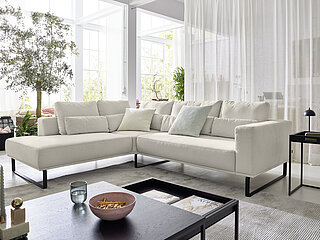 JustB! PM100: Ecksofa bestehend aus Anreihsofa 1-sitzig, medium (60104) mit festem Hocker links, Spitzecke, klein (66020), Anreihsofa 2-sitzig mit Armlehne rechts (22003), Stoff (PG 8, z. B. Easy care white, 100 % Polyester), ca. 232 x 268, H 67/88, SH 47, T 107–123, ST 62–96 cm. Zubehör: Sitzvorzug motorisch, Zwischenhocker (70300), ca. B 90, H 47, T 107 cm, Metallkufen schwarz, matt (260), 1 x Nierenkissen (75630) ca. B 74, H 25, T 11 cm, 2 x Nierenkissen Ecke (75634) ca. B 56, H 25, T 11 cm, 2 x Nierenkissen (75620) ca. B 64, H 25, T 11 cm, 1 x Nierenkissen (75670) ca. B 134, H 25, T 11 cm