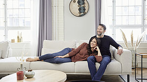 Ecksofa (90114) in Stoff (PG 8, z. B. Stoff Yelda natur, 85 % Polyester, 15 % Viskose), bestehend aus Anreihelement 1,5-sitzig mit festem Hocker links, Spitzecke klein, Anreihsofa 3-sitzig, Armlehne rechts, , Metallkufe schwarz matt (260), ca. 290 x 308, H 67/88, SH 47, T 107/123, ST 62/96 cm, 3 x Nierenkissen groß (75640) ca. 84 x 25 x 11 cm 118,– €, 2 x Nierenkissen (75634) ca. 56 x 25 x 11 cm, Zwischenhocker (70300) ca. B 90, H 47 T 107 cm (Schenkelmaß mit Zw.-Hocker ca. 290 x 398 cm) Metallkufe schwarz matt (260)