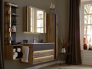 Vorschlag 810368, Korpus Wildeiche massiv lackiert, Front Colorglas graphit / Absetzung Spaltholz Altholz-Eiche, lackiert, ca. B 122, H 200,
T 50 cm, best. aus: Waschtisch-Hängeschrank 810128 mit 1 Auszug oben (Colorglas/Spaltholz) und 1 Schubkasten unten (Spaltholz), ca. B 120,0, H 57,6, T 50,0 cm, Waschtisch 810806 Keramik weiß, mit Überlauf, ca. B 122,0, H 1,6, T 50,0 cm, Spiegelschrank 3-trg. 810050 mit Spaltholz, seitl. LED-Beleuchtung mit Kippschalter zum Schalten der Lichtfarbe und Doppelsteckdose, ca. B 102,0, H 77, T 20 cm
Zubehör (Aufpreis): LED-Spiegelaufsatzbeleuchtung 810928, LED-Waschplatzbeleuchtung 810940, 2 x LED-Griffbeleuchtung 810912, Handtuchhalter 810901 Lack titan für Korpusmontage, ca. L 45 cm