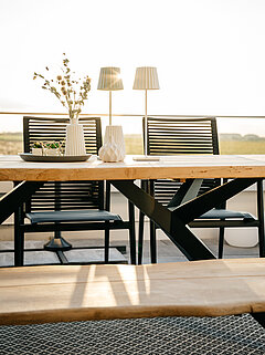 Gartenmöbel Freilicht: Esstisch Holland G299-162-061, ca. 220 x 95, H 76 cm, Gestell: Edelstahl pulverbeschichtet anthrazit, Platte: Teak massiv mit Baumkante, Armlehnstuhl Amsterdam G802-100-100, ca. B 61, H 94, SH 45, AH 64, T 66, ST 46 cm, Sitz: Textilene schwarz, Rücken Kordelbespannung schwarz, Gestell: Aluminium pulverbeschichtet anthrazit mit Armlehnauflagen in Teak massiv