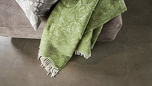 Musterring Heimtextilien: Kissen Blossom ohne Füllung, Fb. grau, 93 % Baumwolle, 7 % Polyester, 45 x 45 cmPlaid Ease mit Fransen, Fb. lind, 50 % Baumwolle, 50 % Acryl, 140 x 200 cm