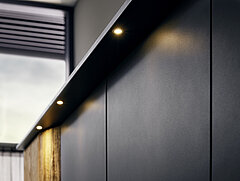 Detail verlichting draaideurkast 6-deurs, 1e + 6e kastdeur eiken met gekloofd hout, 4 deuren in midden lak grafiet, ca. B 298,6, H 222,3, D 66,5 cm (geopend met binnenindeling) in lak grafiet / afwerking wildeiken massief geborsteld met gekloofd hout