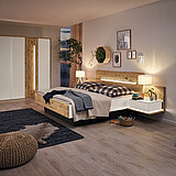 Schlafzimmermöbel Jovanna von Musterring: Drehtürenschrank 6-trg., 2 Designtüren in Absetzung, Bett mit Holzkopfteil und Fußteilblende, Ansatzregal links und rechts mit Ablageboden (Zubehör: Aufsatzschubkasten links und rechts)B 298,6, H 222,3, T 64 cm (Schrank), 180 x 200 cm (Bett), je B 72,3, H 59, T 67,5 cm (Ansatzpaneel), B 58,5, H 22, T 45,1 cm (Aufsatzschubkasten)Lack weiß/Absetzungen Wildeiche massiv