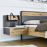 Detail zwevende nachtkastje met elk 1 lade, elk ca. B 65, H 21,8, D 45 cm en hoofdbord bed in lak grafiet/afwerking wildeiken massief geborsteld met gekloofd hout. Toebehoren: Hoofdbord-verlichting en opzetpaneel